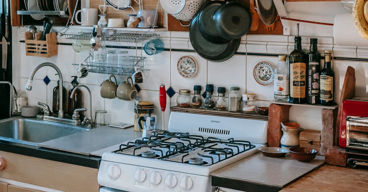 Masonry kitchen furnished with rustic kitchen units and filled with many kitchenware and utensils in sunlight