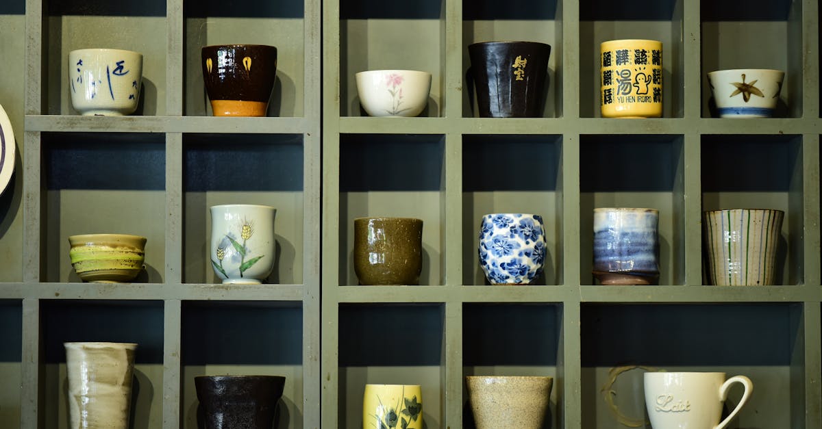 Collection of colorful ceramic mugs showcased on a wooden shelf in grid design.
